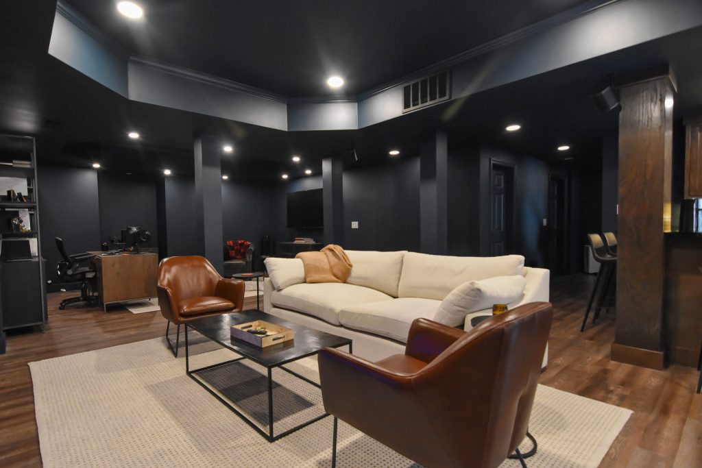 Open finished basement with lounge, home office, and bar across one connected living space