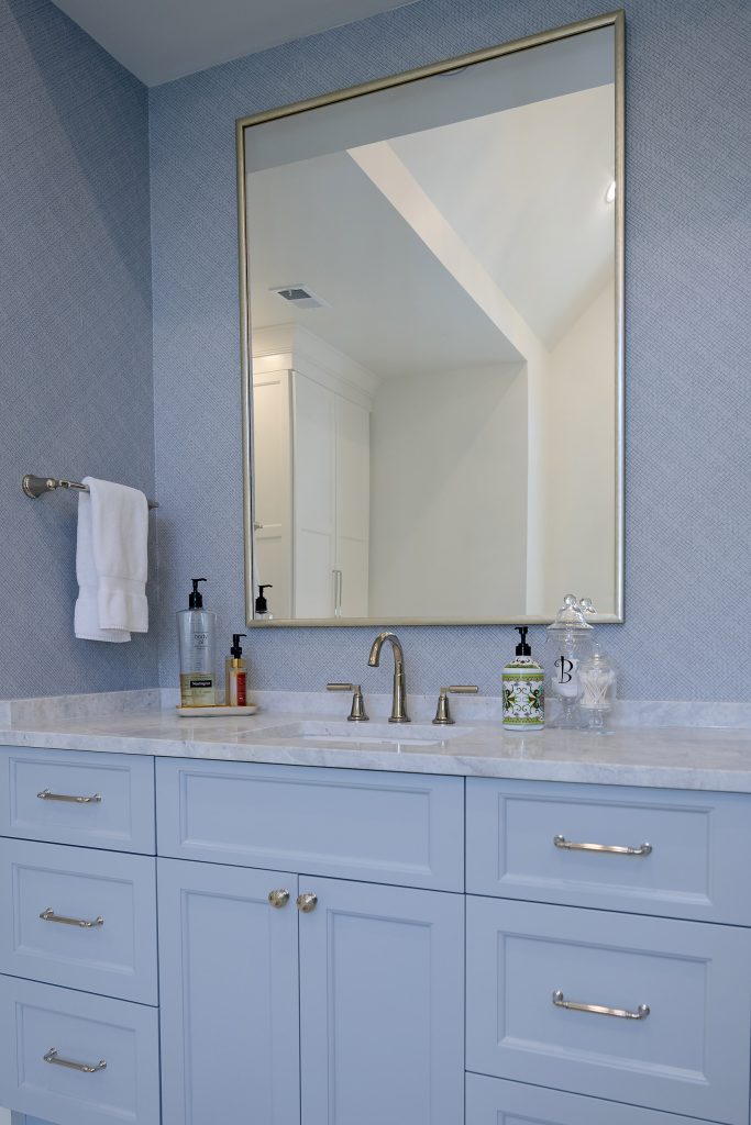 Master bath with a powder-blue double vanity, a glass shower in grey tile, and a freestanding tub.