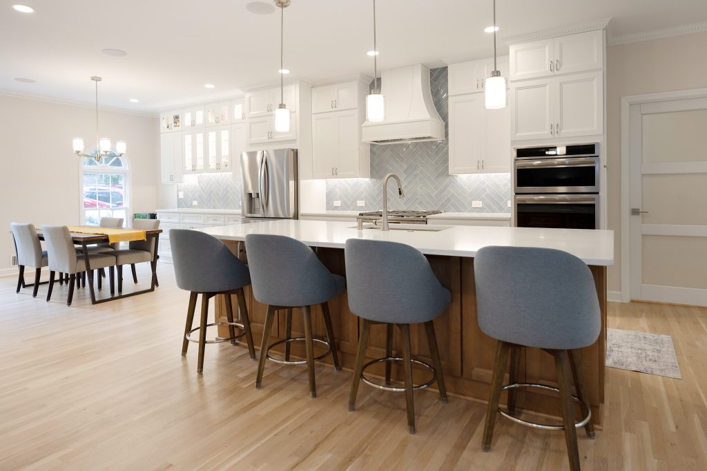 Open plan from the dining table through to the kitchen island, showing how the removed walls tie the rooms together.