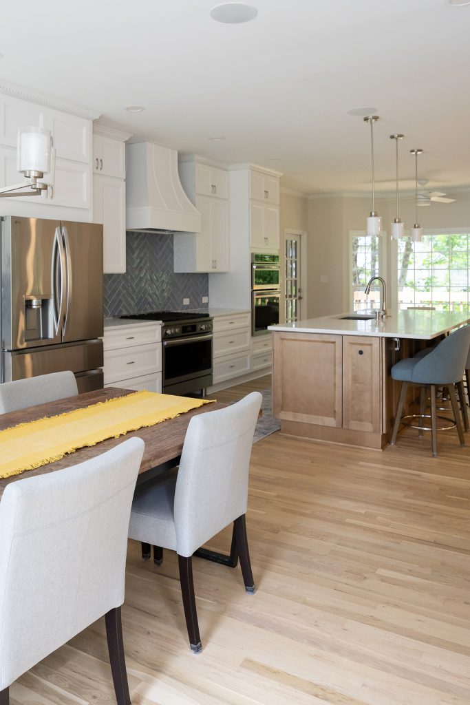 Kitchen from the dining area, with refrigerator, range, island and the porch doors in one open view.